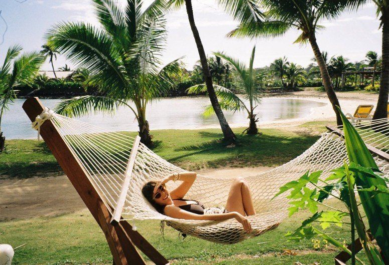 Bayley relaxing in a hammock under palm trees in Fiji