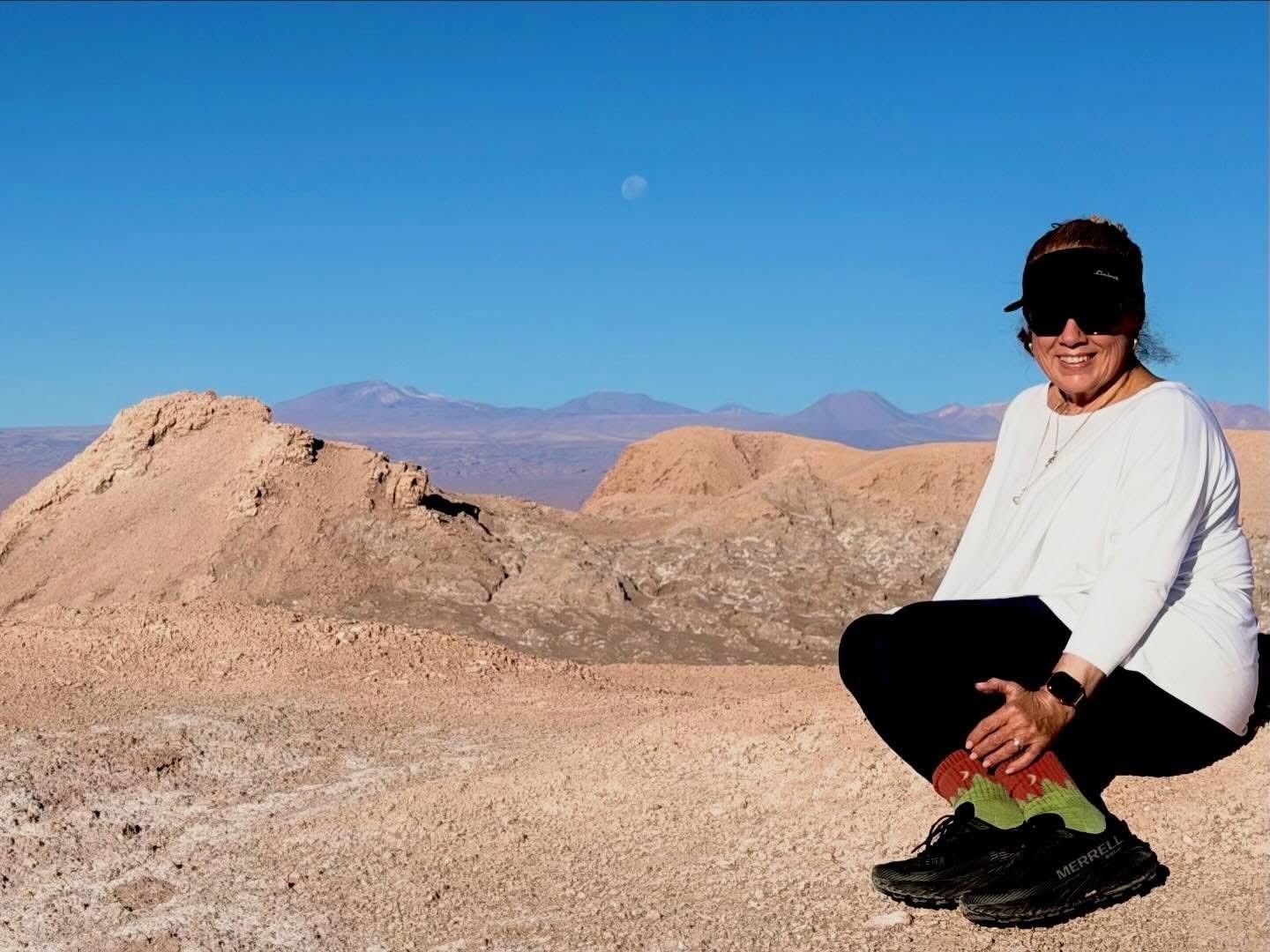 Chrissy in the Atacama Desert, Chile, with the moon overhead